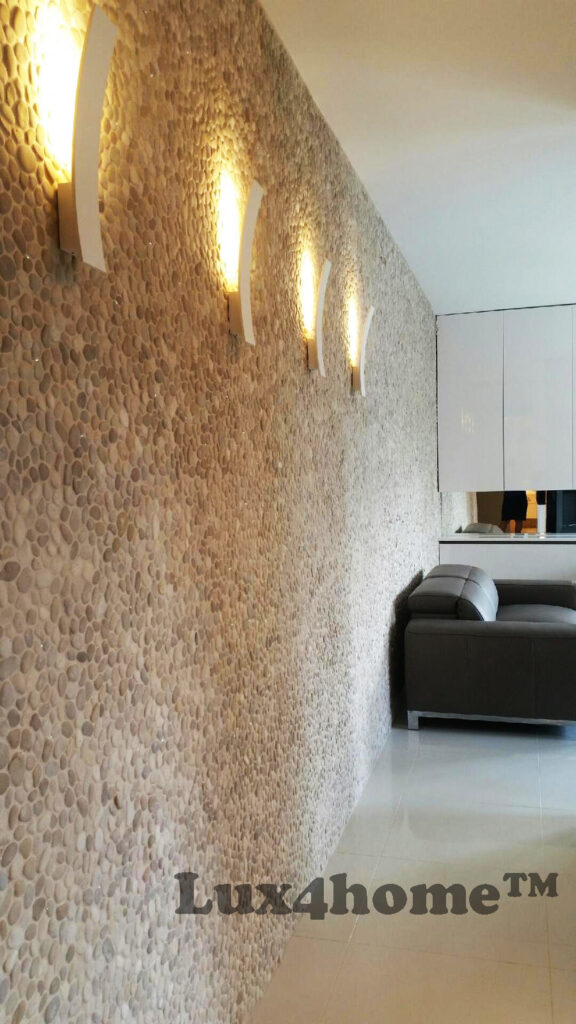 Mozaika z otoczaków MALUKU TAN na ścianie apartamentu 16 Mozaika MALUKU TAN w ciepłym świetle kinkietów, ujęcie wzdłuż ściany