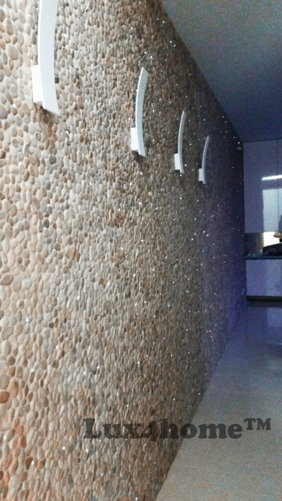 Mozaika z otoczaków MALUKU TAN na ścianie apartamentu 13 Ściana z otoczaków MALUKU TAN i kinkietami, widok wzdłuż okładziny