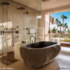 Wanna FLUMEN z kamienia rzecznego Wanna FLUMEN z kamienia rzecznego w łazience z prysznicem i widokiem na palmy